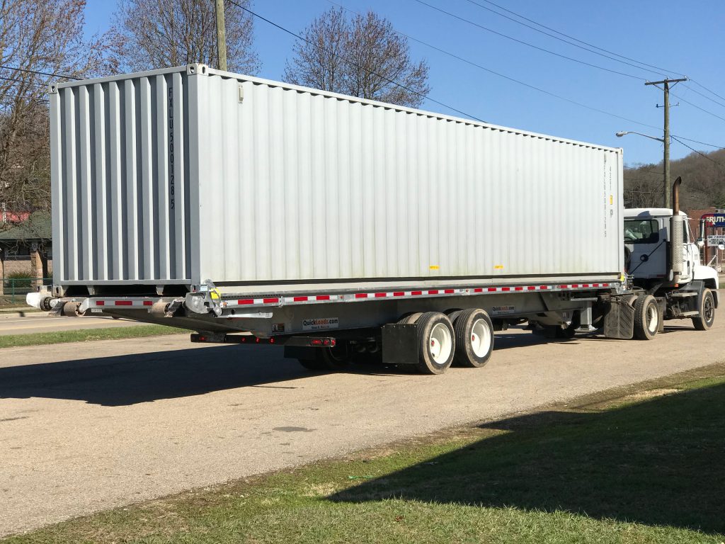 A 40' QuickLoadz trailer with a shipping container loaded on the bed.