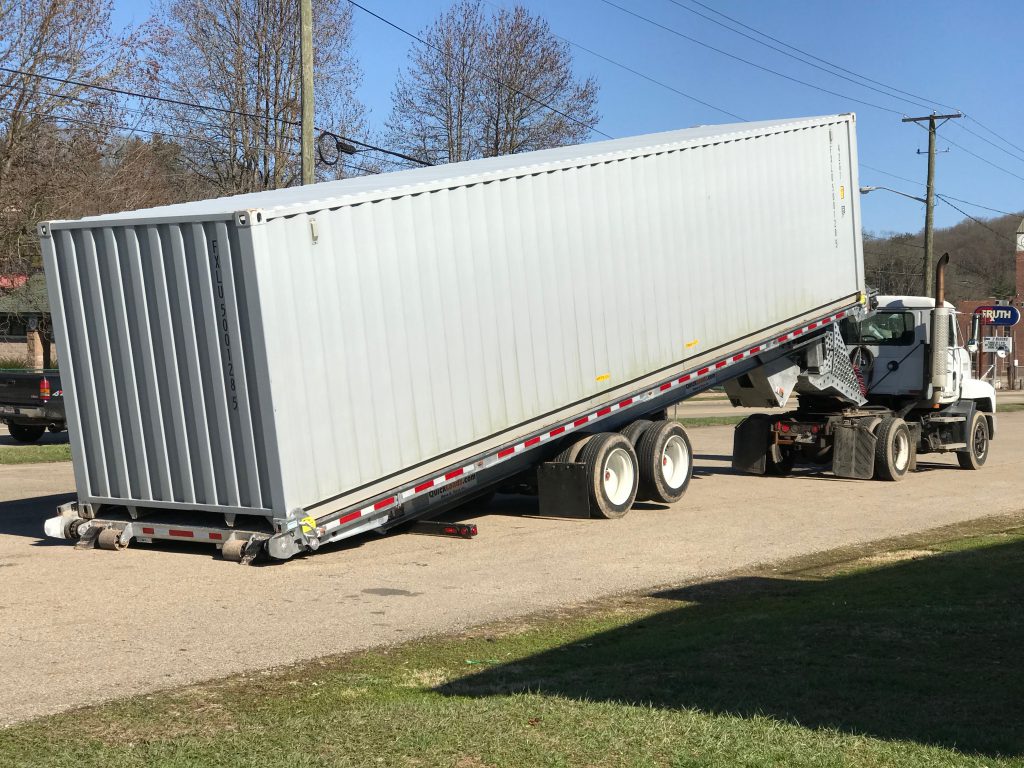 A QuickLoadz trailer at an angle with a shipping container loaded.