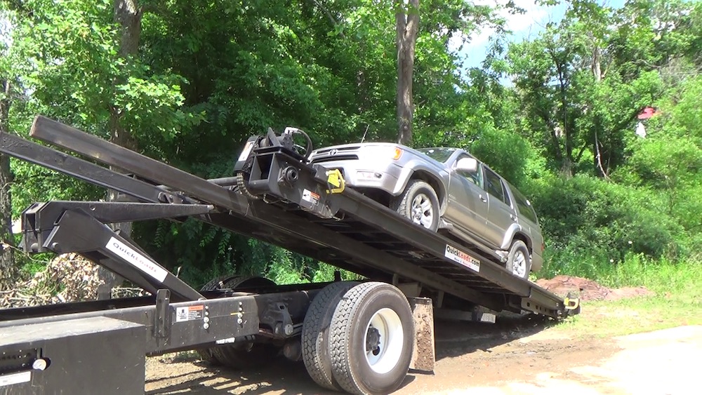 A QuickLoadz trailer being loaded with a car. The trailer can be used as a tow truck with the tow package.